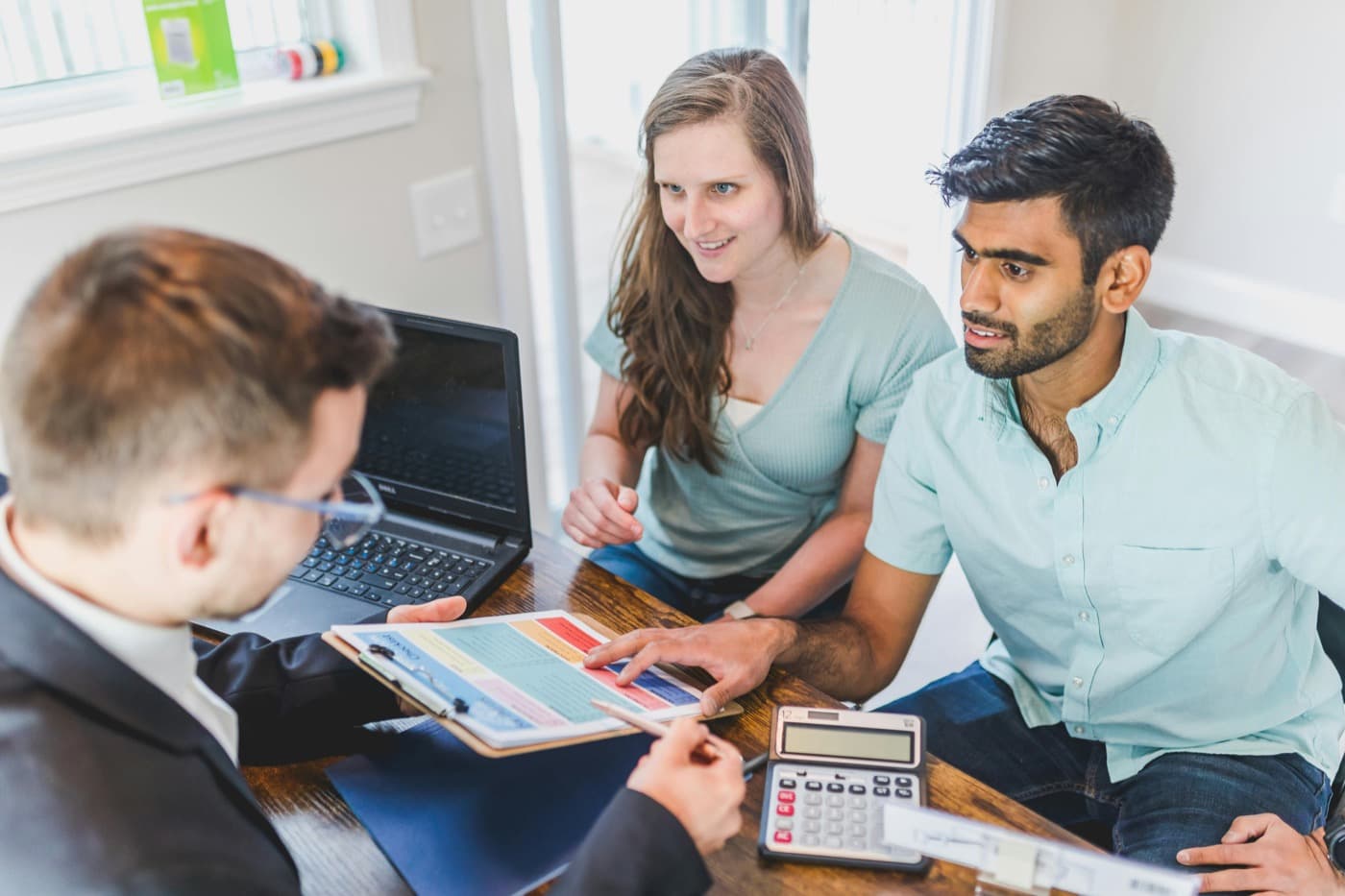 Consulta inmobiliaria con clientes revisando información de una propiedad